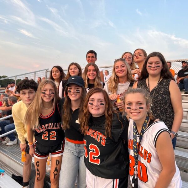 An exchange student with her American high school friends attending a football game.