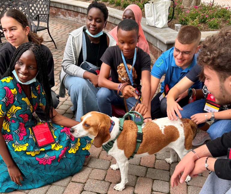 A group of foreign exchange students petting a dog