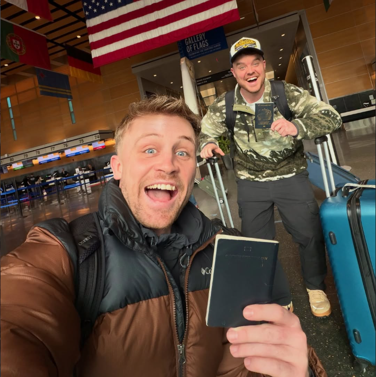 Josh and Jase smiling with their passports in the airport