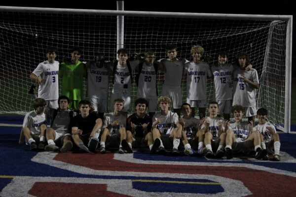 Luca poses with his soccer team in front of the goal