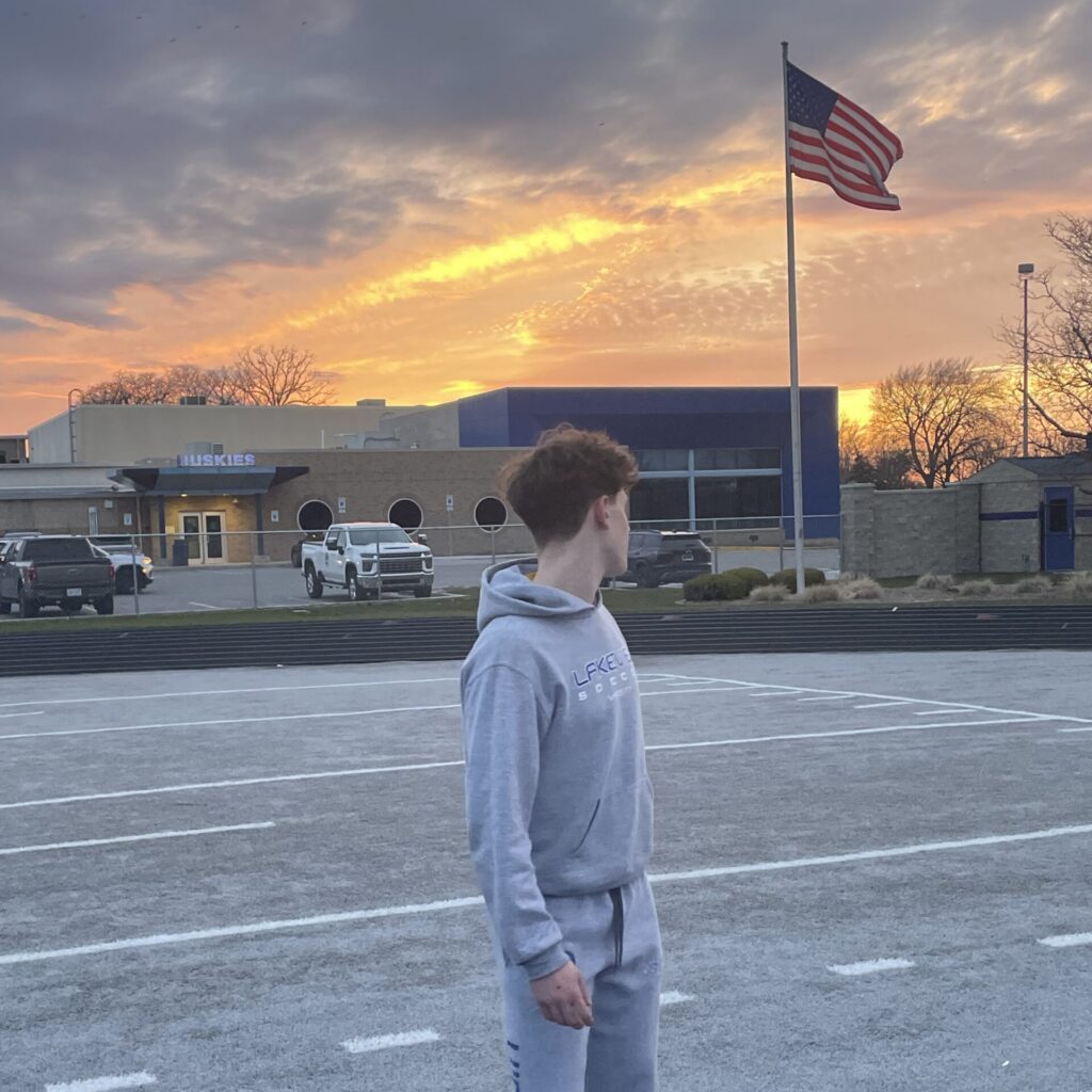 An exchange student looks at the sunrise over his American high school